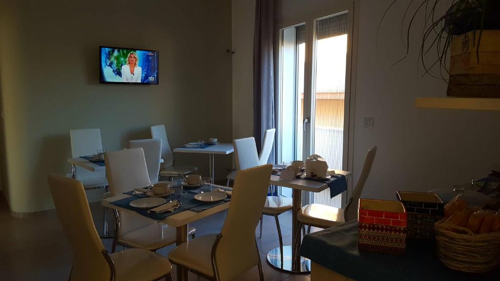 莱韦拉诺Il Matino的一间带桌椅和电视的用餐室