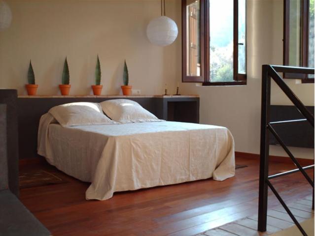 AlmedíjarCasa Rural Pico Espadan的一间卧室配有一张带白色床单的床和一扇窗户。
