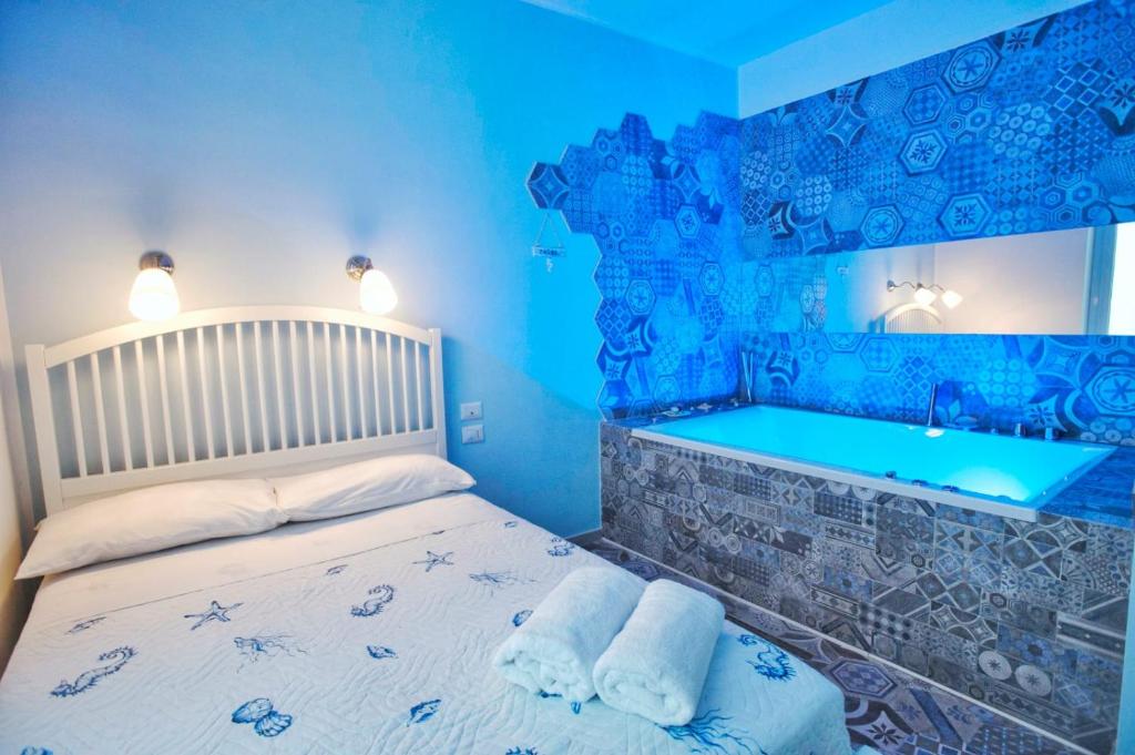 萨莱诺Nereidi Suites的蓝色卧室配有一张床和一个浴缸