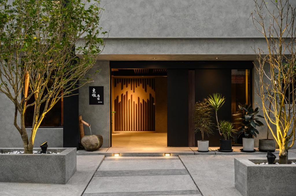 礁溪东旅汤宿温泉饭店-风华漾馆的一座种植盆栽植物的建筑的前门