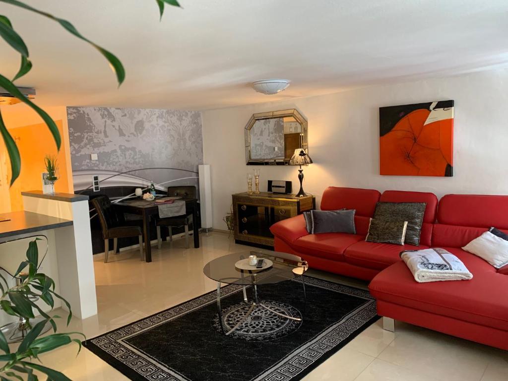 菲林根-施文宁根Luxus Domizil的客厅配有红色的沙发和桌子