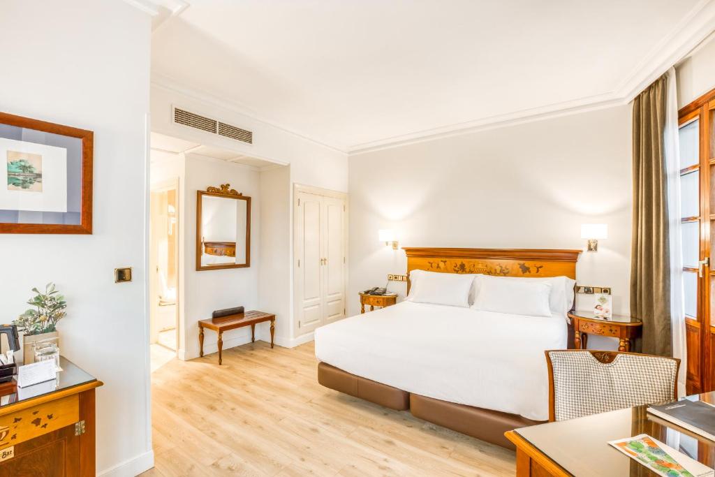 毕尔巴鄂Sercotel Arenal Bilbao的配有一张床和一张书桌的酒店客房
