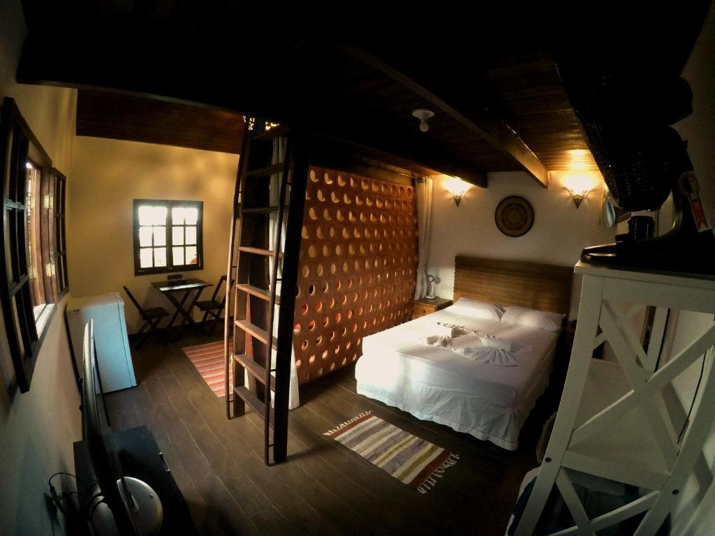 安格拉杜斯雷斯Chalés da Longa的一间卧室设有一张床和梯子