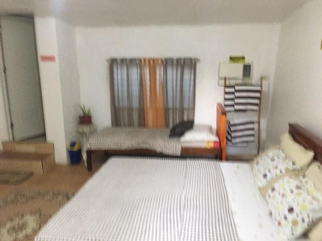 DaanbantayanD & N LODGE的一间卧室配有一张床和一张沙发