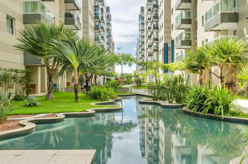 马塞约Apartamento Beira Mar Maceió的一座棕榈树和建筑游泳池