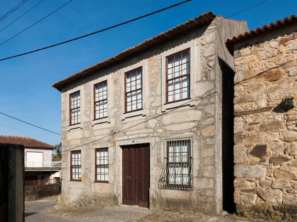 PedrosoCasa do Sobreiro的一座古老的石头建筑,设有棕色的门