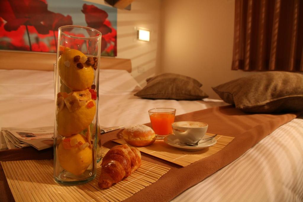 里乔内伊拉里奥套房酒店的一张桌子,上面有花瓶,床上有食物和饮料