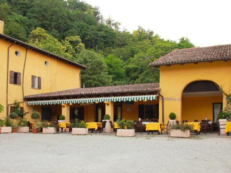 TeoloAgriturismo Ca Noale的庭院内一座黄色建筑,配有桌椅