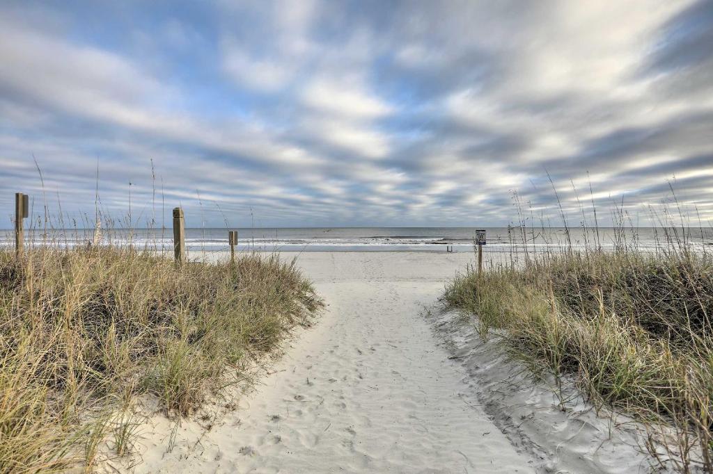 默特尔比奇Steps to Ocean Breezy Myrtle Beach Bungalow!的海滩上穿过沙滩的路径