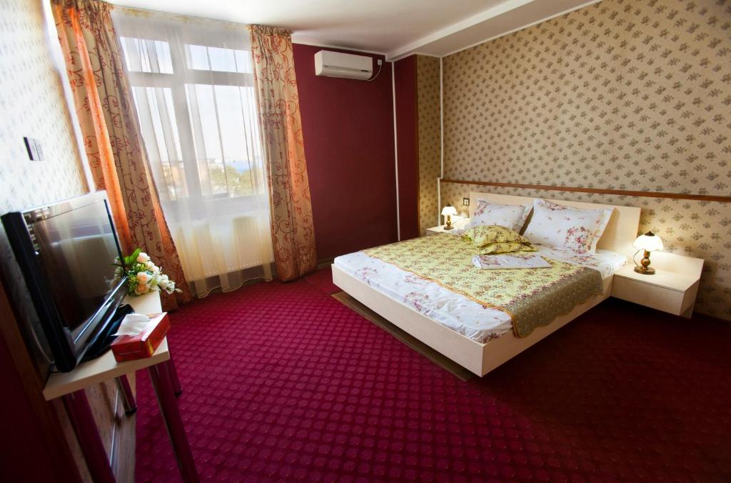 布加勒斯特拉吉尔酒店的一间卧室设有一张床、一台电视和一个窗口。