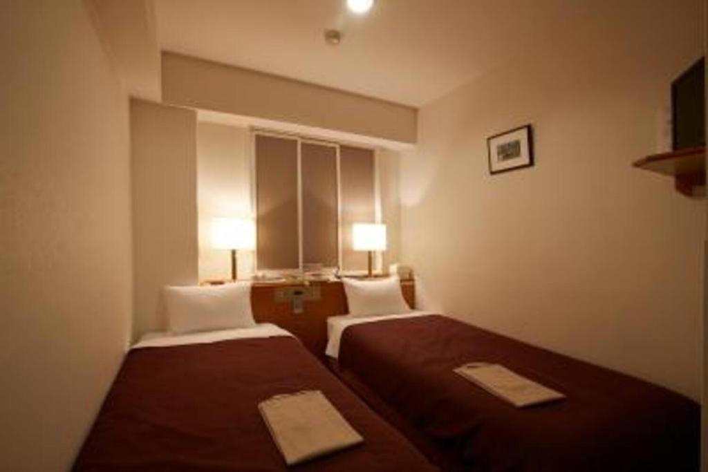 高山Country Hotel Takayama - Vacation STAY 67710的酒店客房设有两张床和窗户。