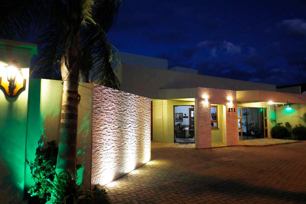 圣加布里埃尔Hotel Zona Sul的一座在晚上有棕榈树的建筑