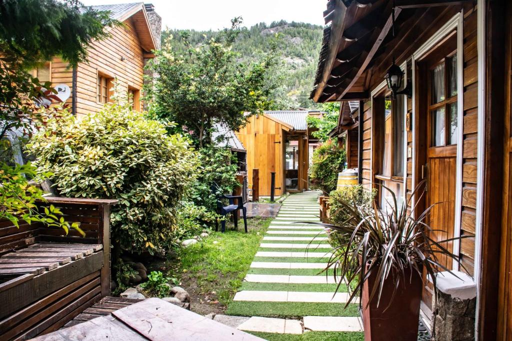 圣马丁德洛斯Cabañas de la Patagonia的两所房子之间在院子里的走道