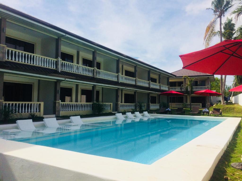 邦劳Portofino Panglao Bohol的酒店设有带椅子和遮阳伞的游泳池