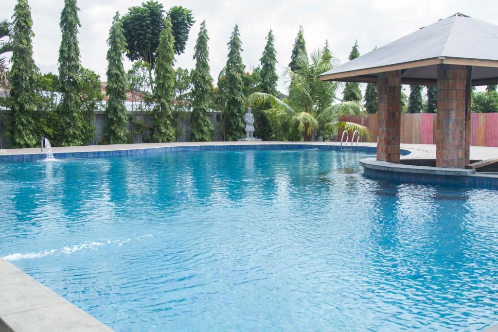 棉兰Thong's Inn Hotel Kualanamu的一个带凉亭的大型蓝色游泳池