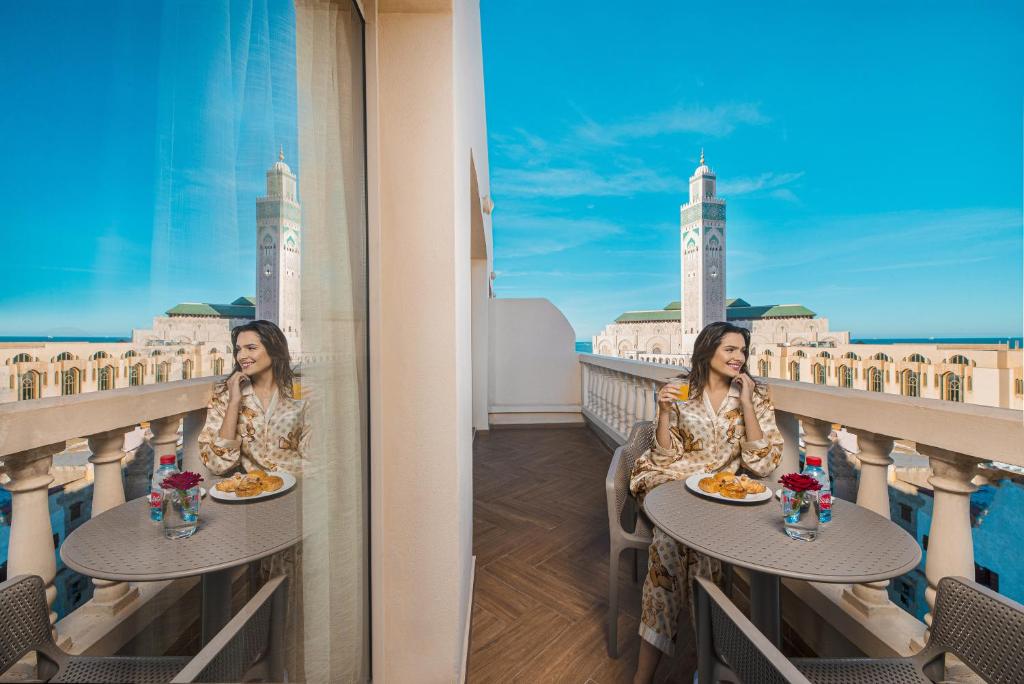卡萨布兰卡美利博尔公寓式酒店的坐在阳台上吃食物的女人