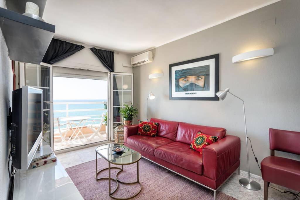 皮内达德马尔Apartment in front of the Beach的客厅内的红色沙发,享有海景