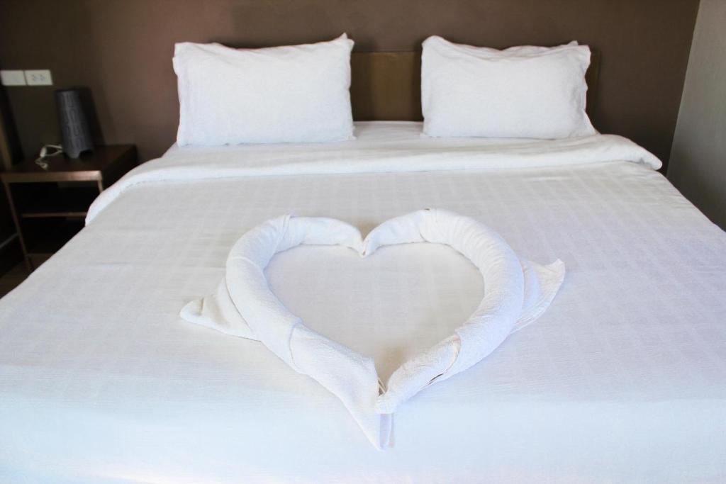 黎府Plus Hotel的白色的心,床上有白色的床单