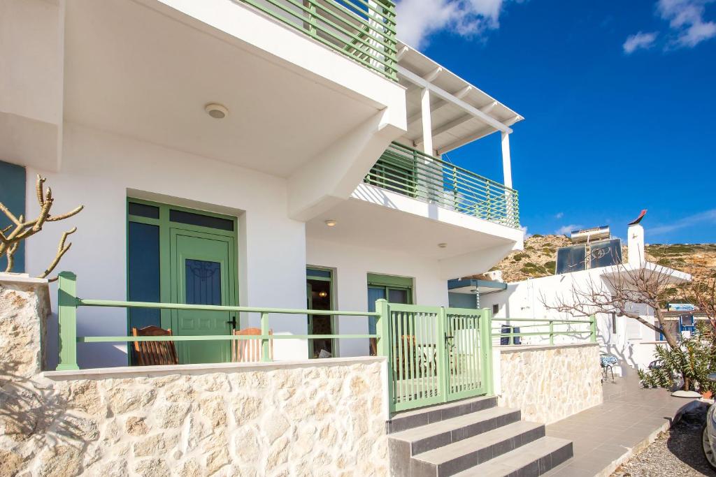 阿彻奇洛斯EGLI LUXURY APARTMENTS的白色的房子,设有绿色的门和楼梯