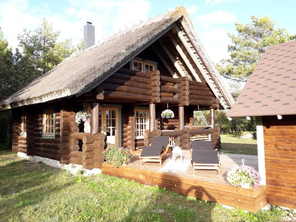 KõigustePähkli Seaside Cottage with Cozy Outdoor Patio的庭院内带椅子和甲板的小木屋