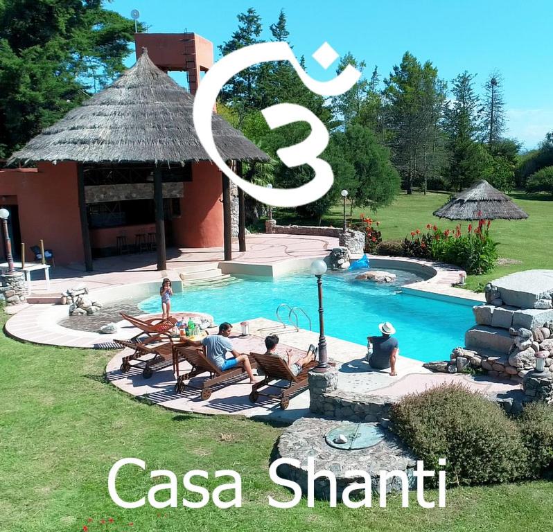 吉亚迪诺镇Casa Shanti Posada Boutique的一群人坐在游泳池周围
