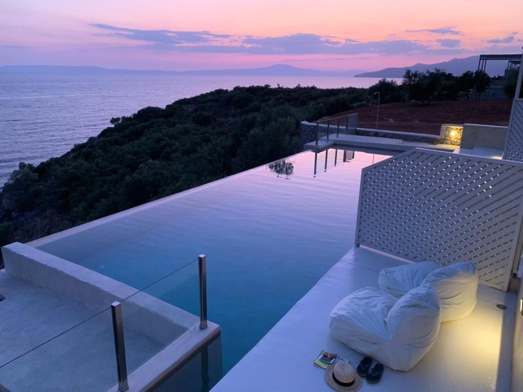卡德哈米利Katikies Manis Suites的日落时分享有海洋美景的阳台