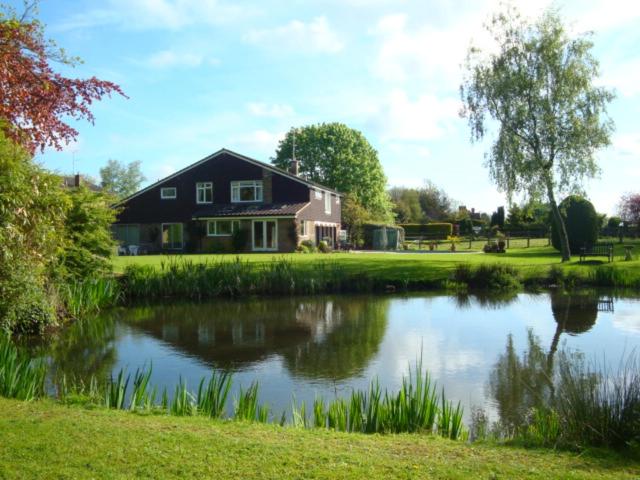 BeningtonCobblestones的房屋前有池塘的房子