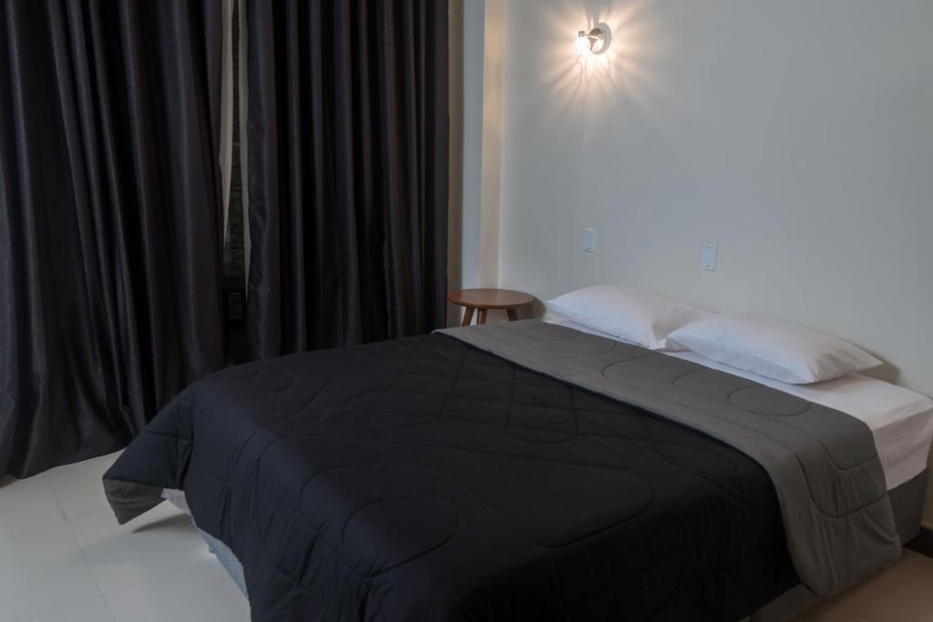通贝斯MiniApartamentos GRAN IMPERIAL PREMIUM的一间卧室配有一张床上的黑色毯子