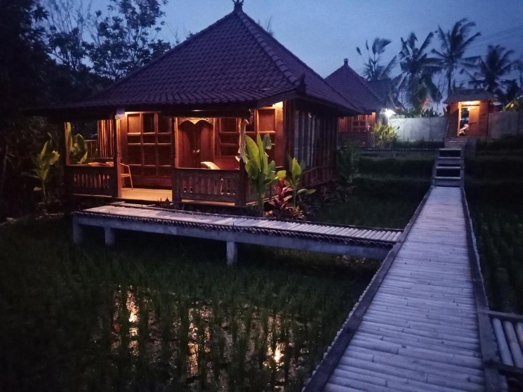 德格拉朗Ubud Sawah Scenery Villa and Homestay的池塘中央的小屋