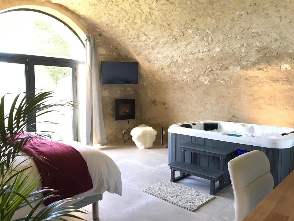 ReillanneParadise Love In Provence - loft en pierres - spa privatif的一间带浴缸的浴室,位于一个窗口的房间