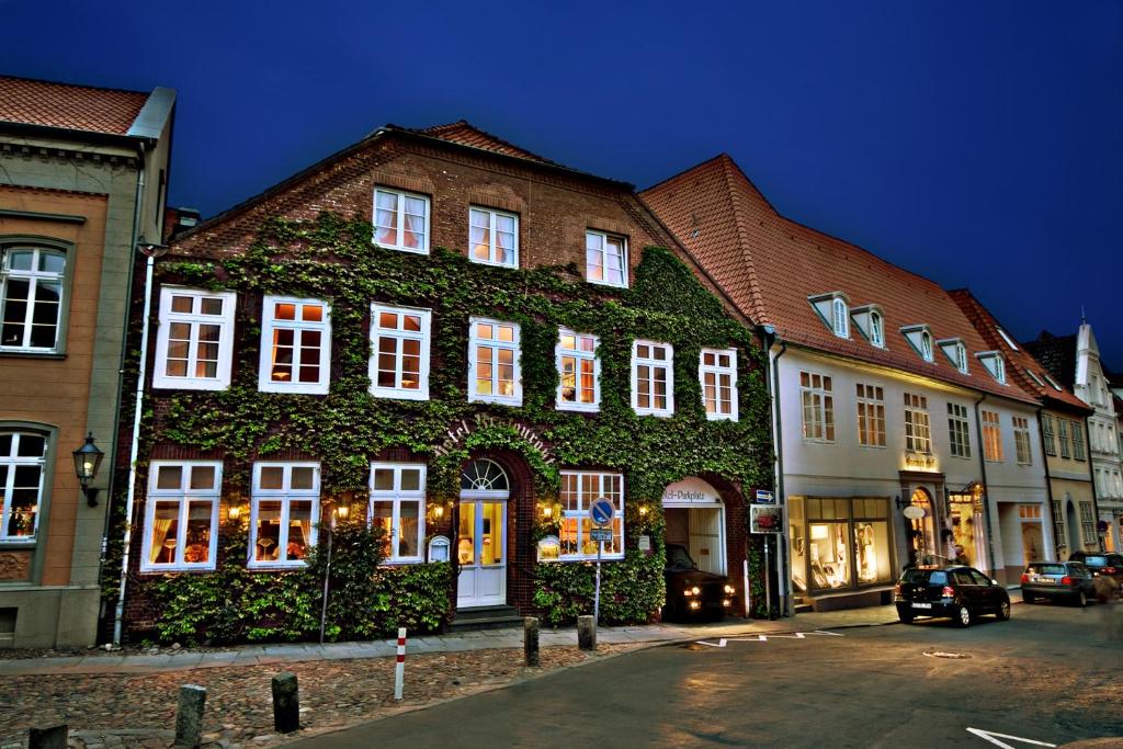 吕讷堡Hotel Bremer Hof的常春藤长在街上的建筑