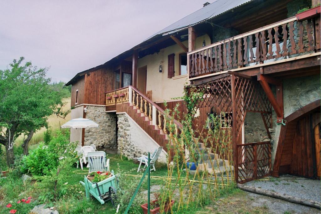 Prunières提浓斯度假屋的带阳台、桌子和雨伞的房子