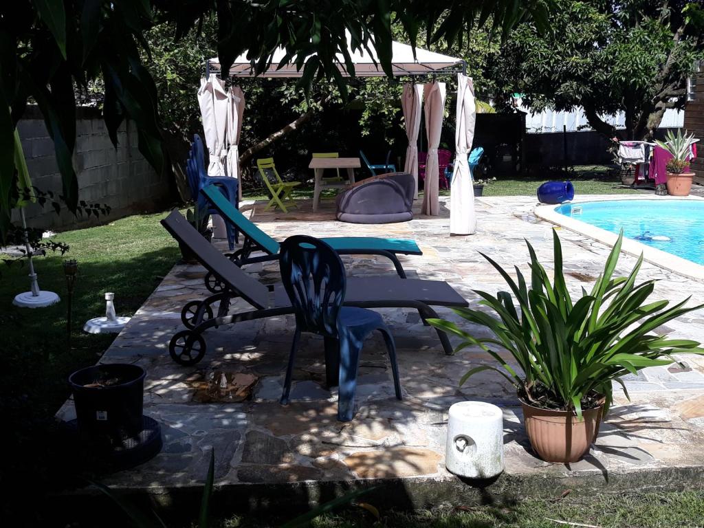 Ducosvilla do brazil的一个带椅子和桌子的游泳池以及一个游泳池
