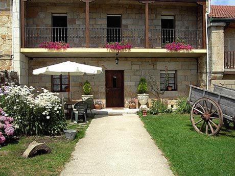 Santa GadeaHotel Rural El Rincón de Gadea的院子里带桌子和雨伞的房子