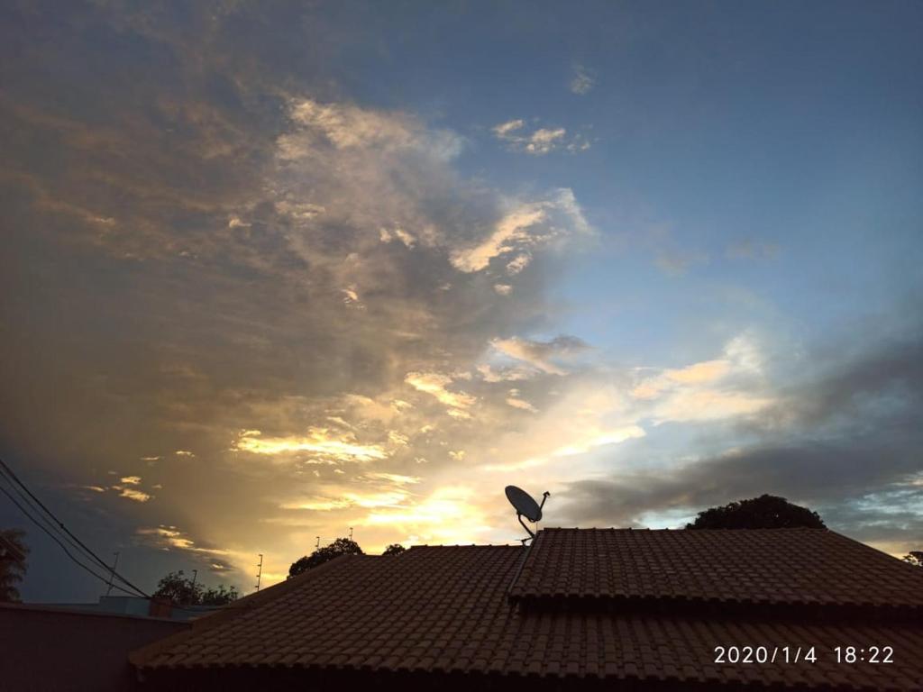 多拉杜斯DOURADOS GUEST FLAT HOUSE的鸟坐在屋顶上,天空阴云