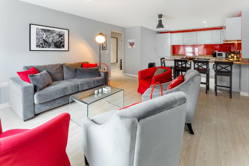 利物浦Centrally located apartment in Duke Street- free parking- two bathrooms的带沙发和红色椅子的客厅以及厨房。