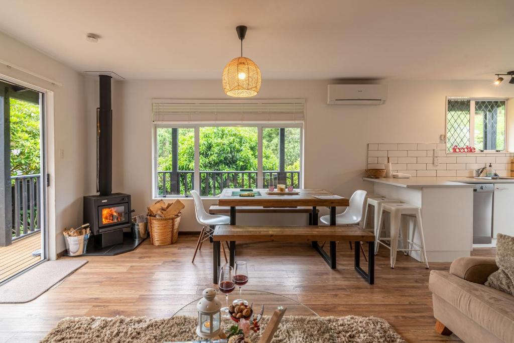 阿卡罗阿La Petite Maison - Akaroa Holiday Home的客厅配有桌子和壁炉