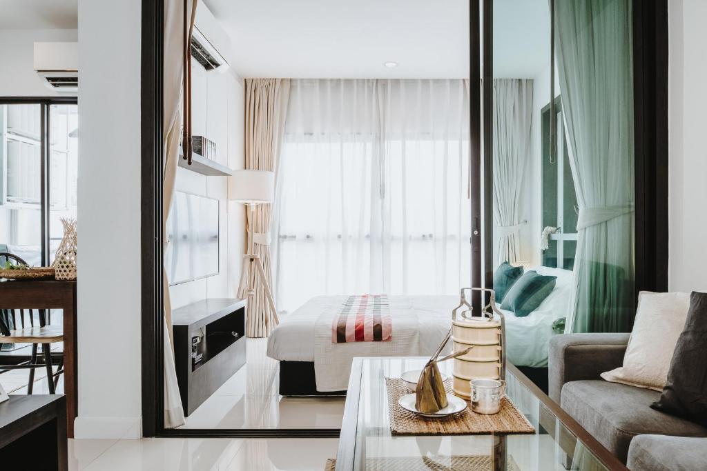 曼谷Siamplaengna Residence สยามแปลงนา เรสซิเดนท์的酒店客房设有床和客厅。