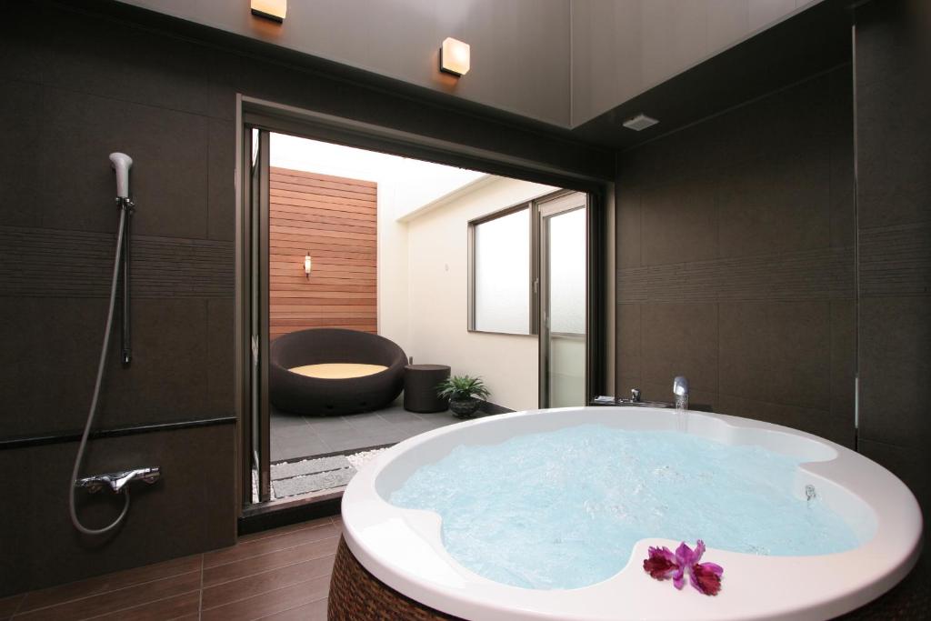 KoshigayaHOTEL W-PREMIUM -W GROUP HOTELS and RESORTS-的带浴缸的浴室和大窗户