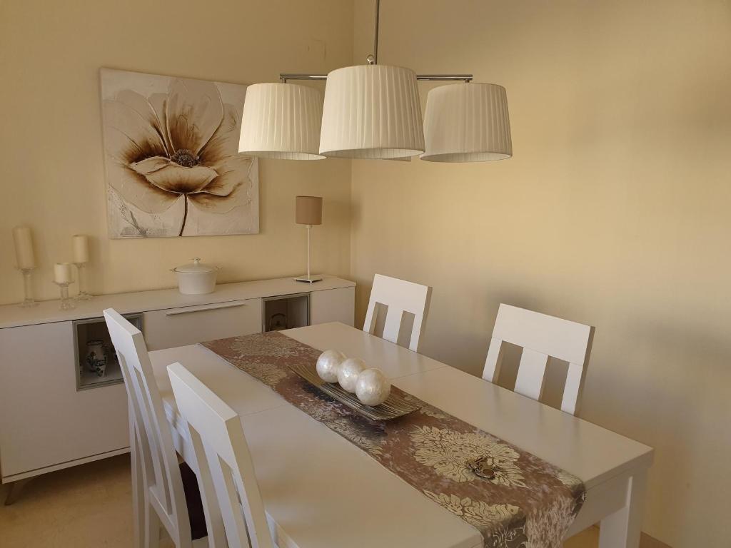 哈恩Jaen Home的一间配备有白色桌椅的用餐室