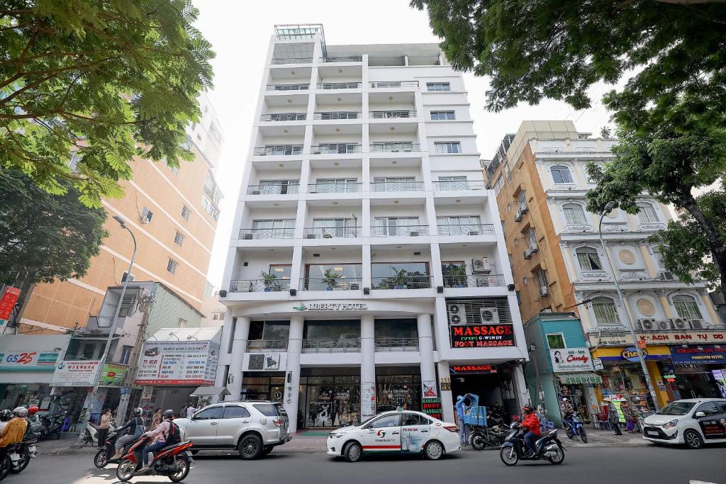 胡志明市西贡景园自由酒店的城市街道上高大的白色建筑,有汽车