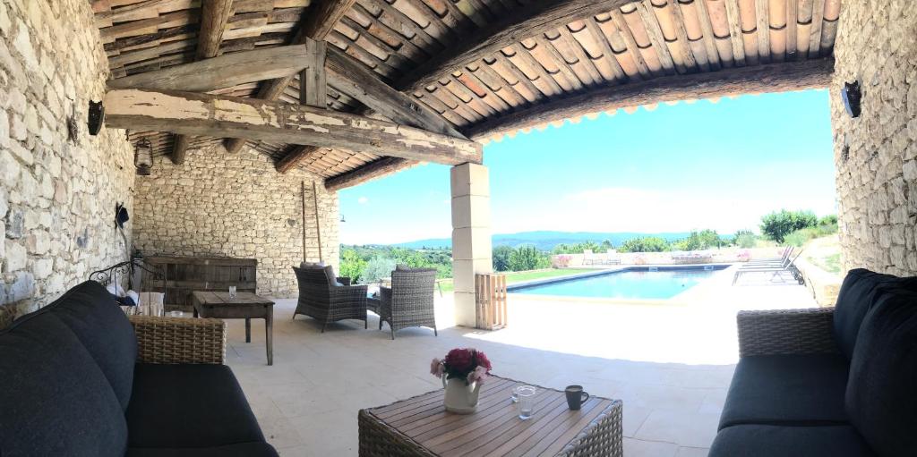 圣萨蒂南艾普特Le Mas Silvestre的带沙发和桌子的庭院以及游泳池。
