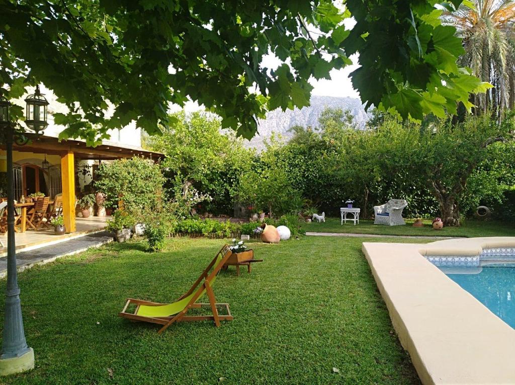 BeniarbeigCasa la Gaspareta的一个带游泳池、椅子和房子的庭院