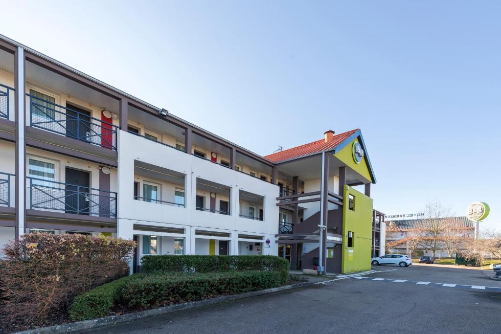 莫内托B&B HOTEL Auxerre Bourgogne的公寓大楼拥有黄色和白色