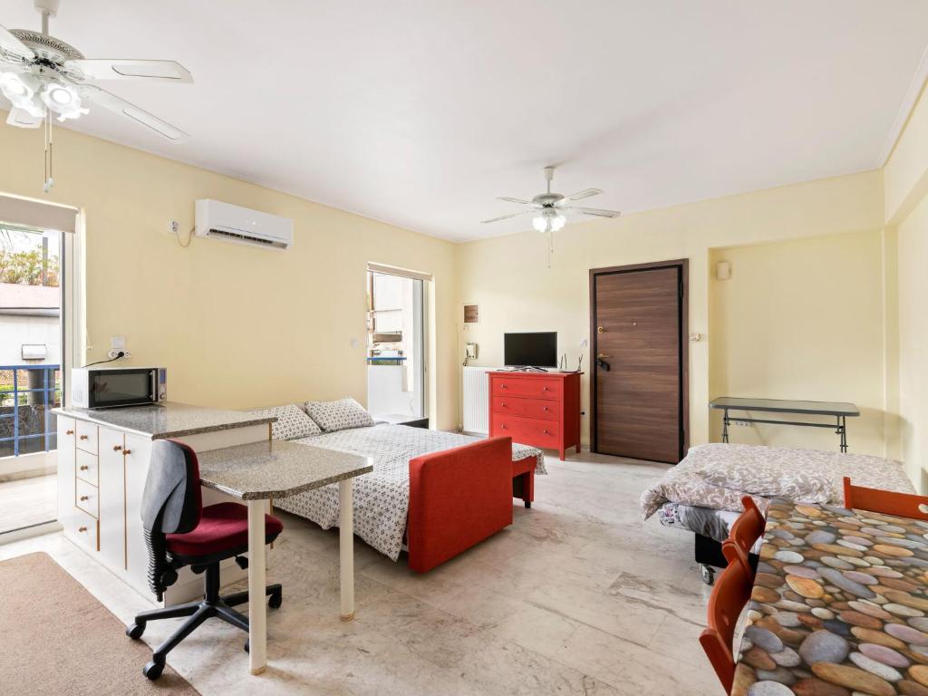 雅典Homely Apartment in Piraeus with Balcony的一间卧室配有一张床、一张桌子和一张床,一间房间