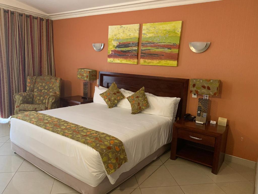 波罗瓜尼Royal Hotel的配有一张床和一把椅子的酒店客房