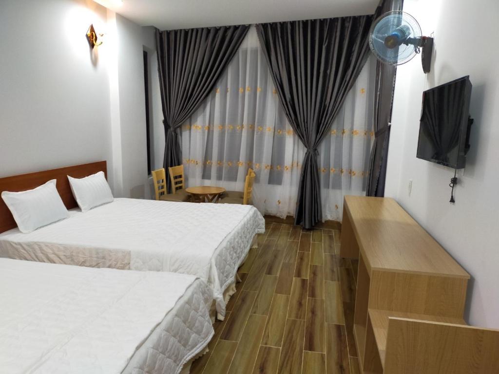绥和市Hotel Hiệp Thành的酒店客房设有两张床和电视。