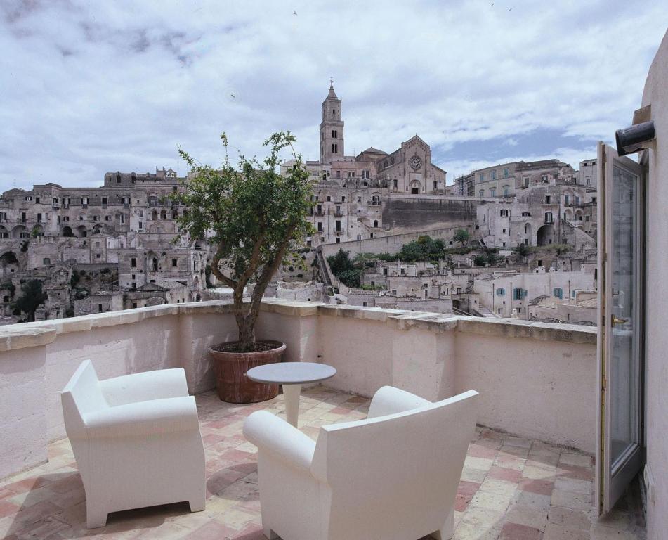 马泰拉萨希酒店的阳台享有城市美景,配有桌椅。