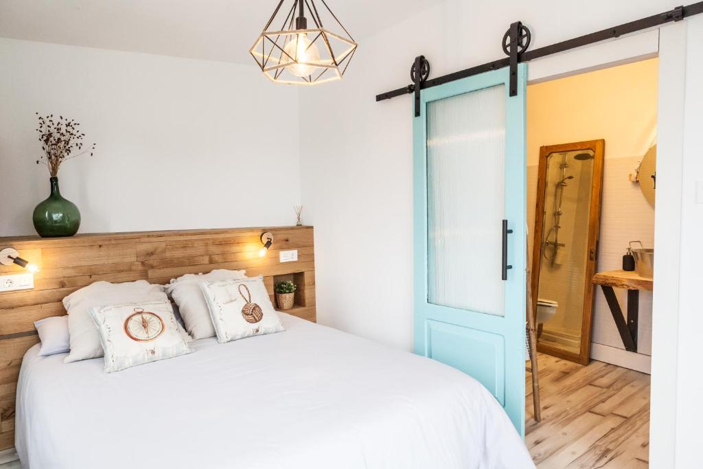 塞洛里奥The Old Seaman Bed & Breakfast的卧室配有白色的床和蓝色的门