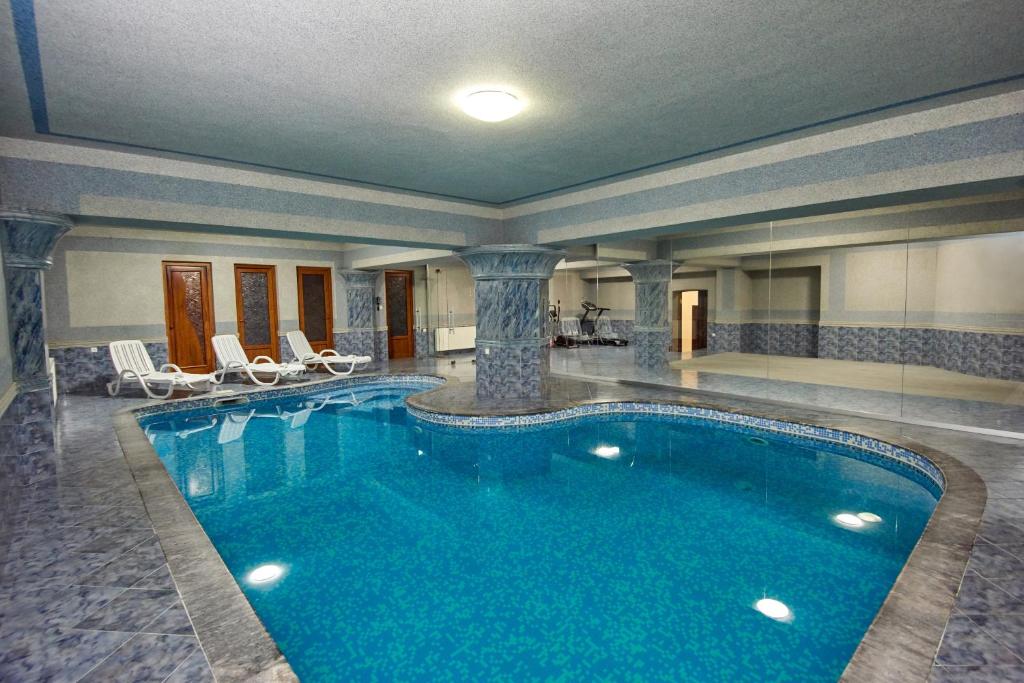 第比利斯S&L Boutique Hotel的酒店客房的大型游泳池配有椅子